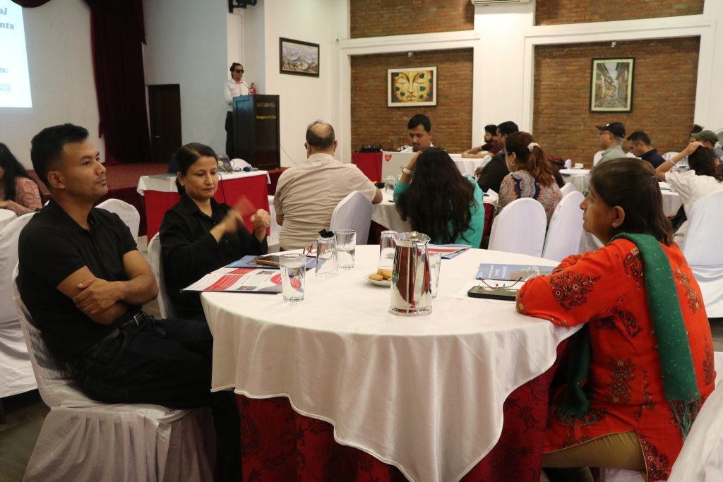 Deaf Participants seated with SLI doing sign language and other participants behind